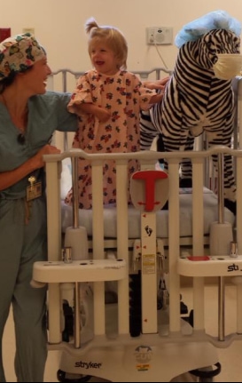 Image of young child with doctor and zebra (stuffed)