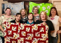 Image of families holding up quilts