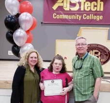Girl standing with parents holding certificate