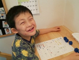 Young boy smiling at school desk