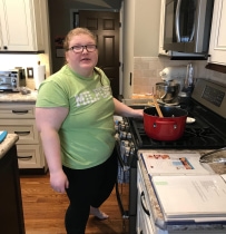 Girl standing over stove cooking